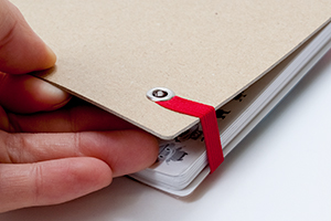 ネセサリワークス株式会社　様オリジナルノート 書きま帳ゴムバンドPLUS にセットになっている「特厚台紙」と「ゴムバンド加工」でオリジナルノートをしっかりとめられる。